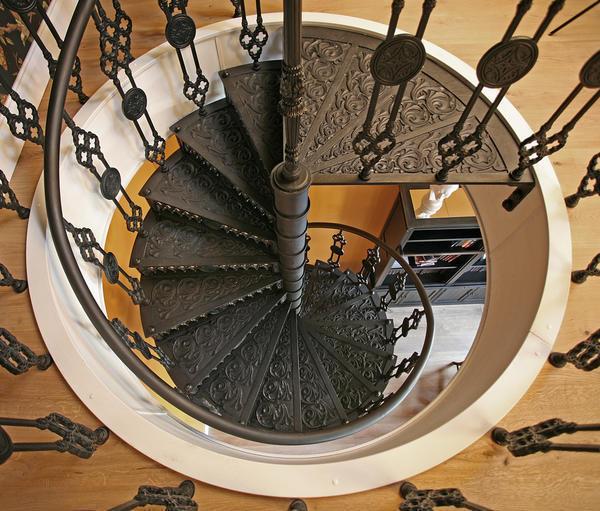 Для гостиной в классическом стиле отлично подойдет кованая винтовая лестница с интересным узором 