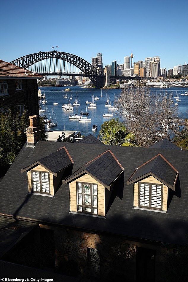 A house is pictured by the waterfront with the Sydney Harbour Bridge seen in the distance