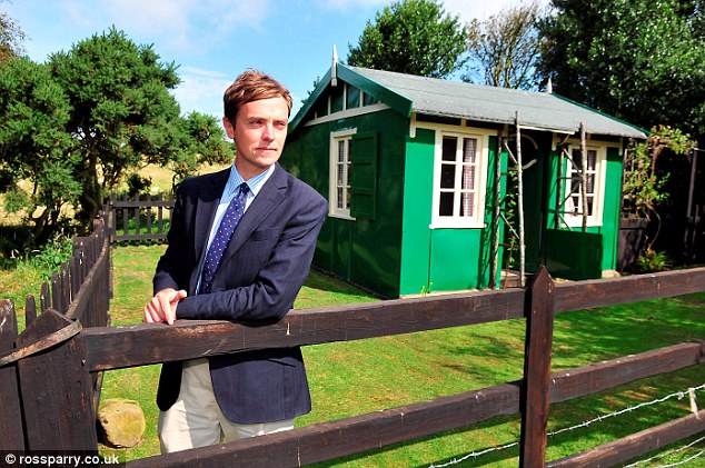 For sale: Auctioneer Tom Watson standing outside the holiday chalet in Staintondal, North Yorkshire