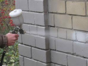 Нанесение жидкого утеплителя на стену при помощи распылителя